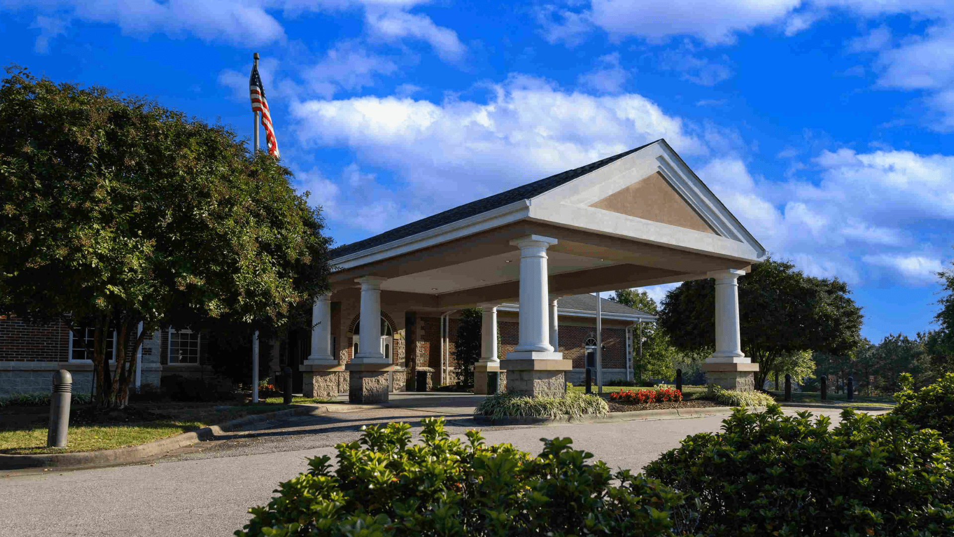 Entrance to Granville Primary Care with with an American Flag pole and greenery surrounding the entrance