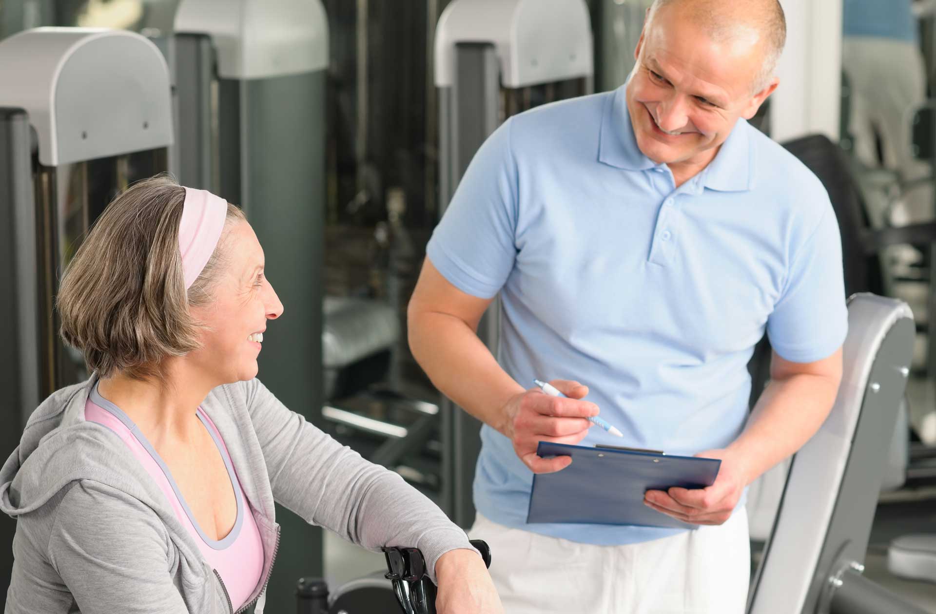 Physical therapist speaks with a patient in a rehabilitative center's gym