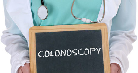 Photo of doctor holding small chalk board that says colonoscopy