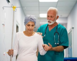 Healthcare professional helping a woman with an IV pole walk | Granville Health System