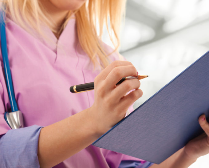 Young nurse writing medical records