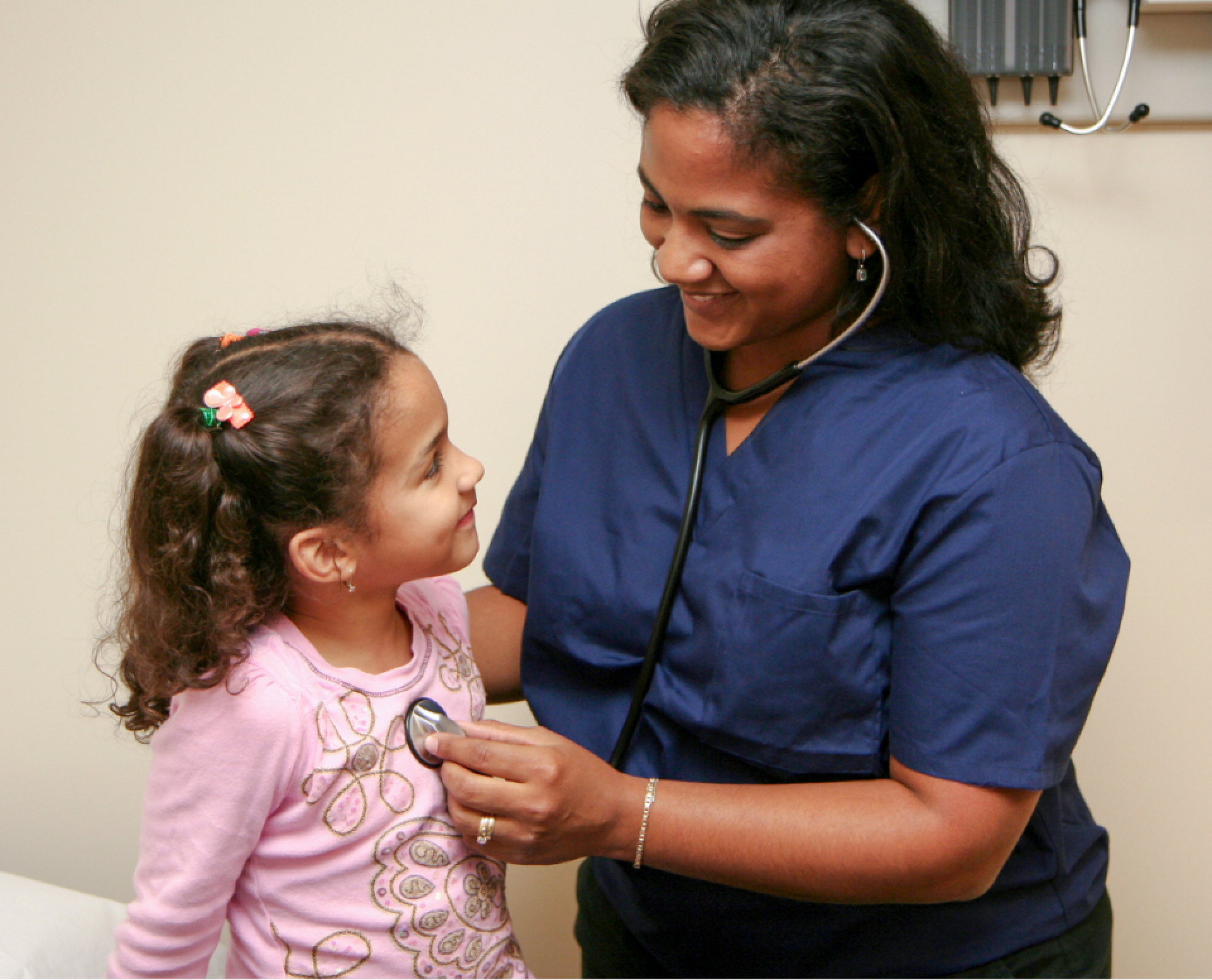 Healthcare professional listens to child's heartbeat with a stethoscope